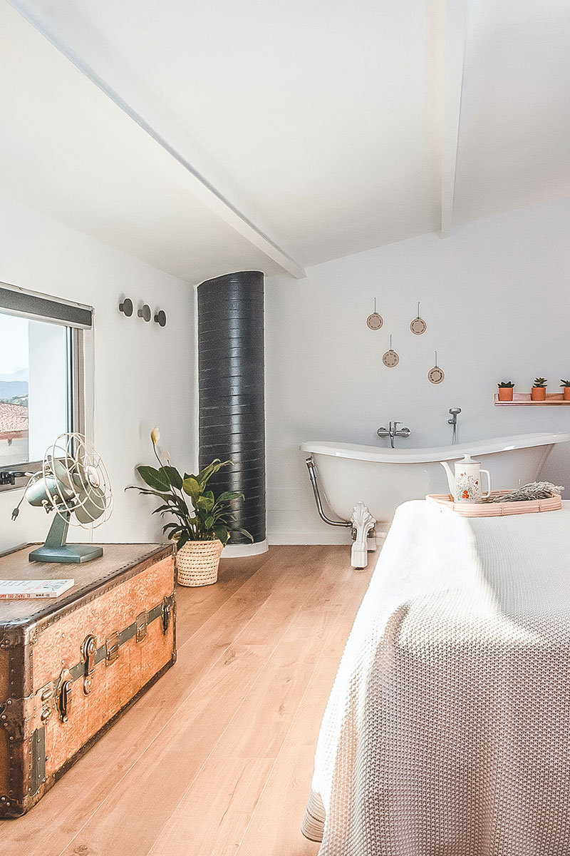Foto decoración de habitación Suite con baúl, bañera y planta