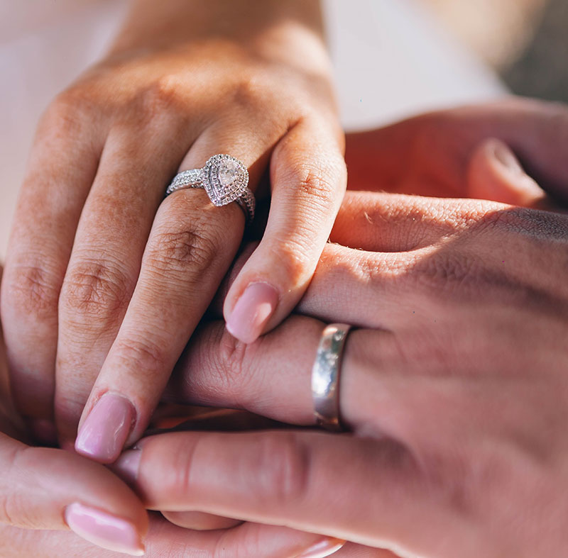 Foto de las manos de una pareja con anillos de compromiso